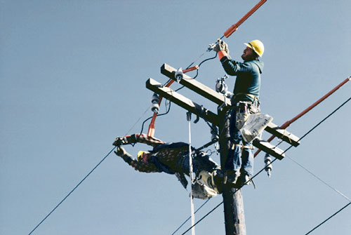 electricians performing maintenance on a power line