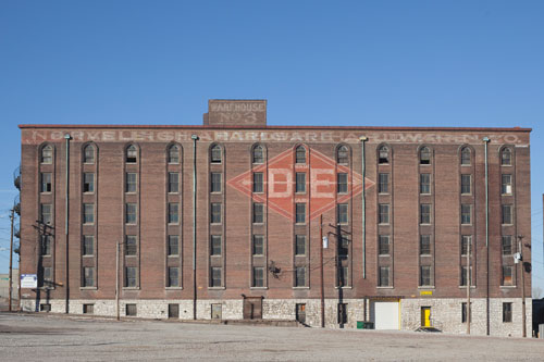 run-down warehouse with a D E logo on it