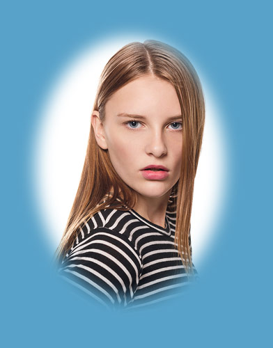 female model wearing striped shirt looking at camera with white background